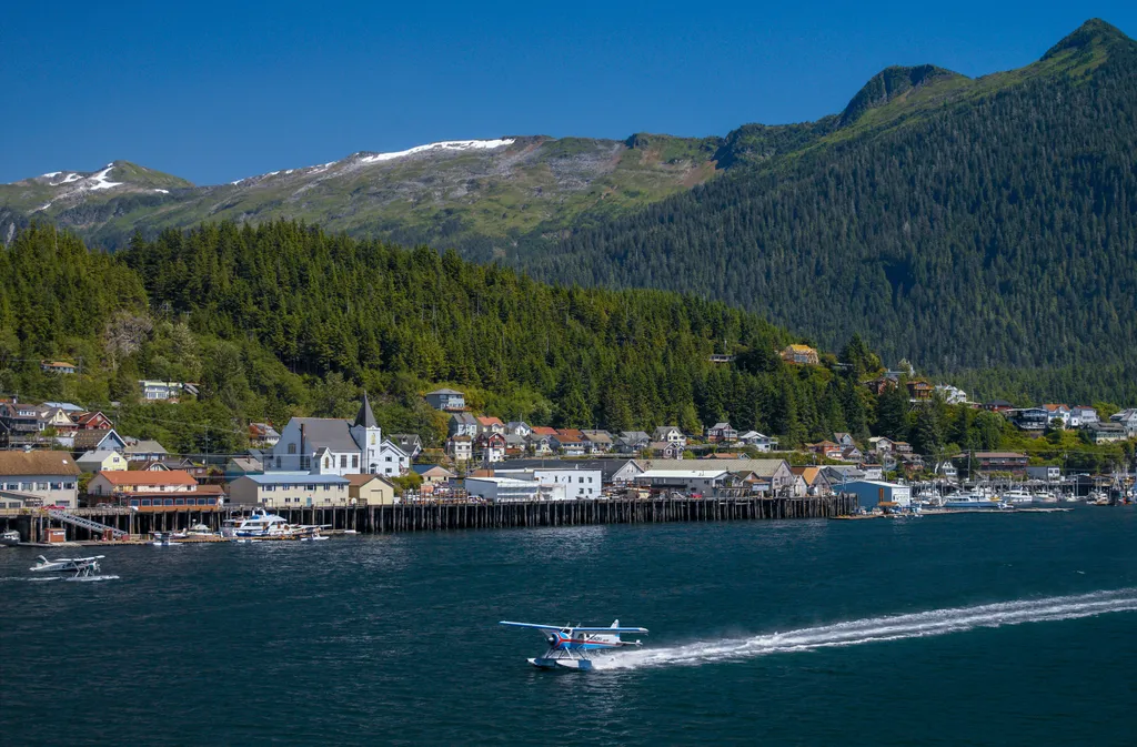 Floatplane landing on an Alaska waterway surrounded by wilderness
