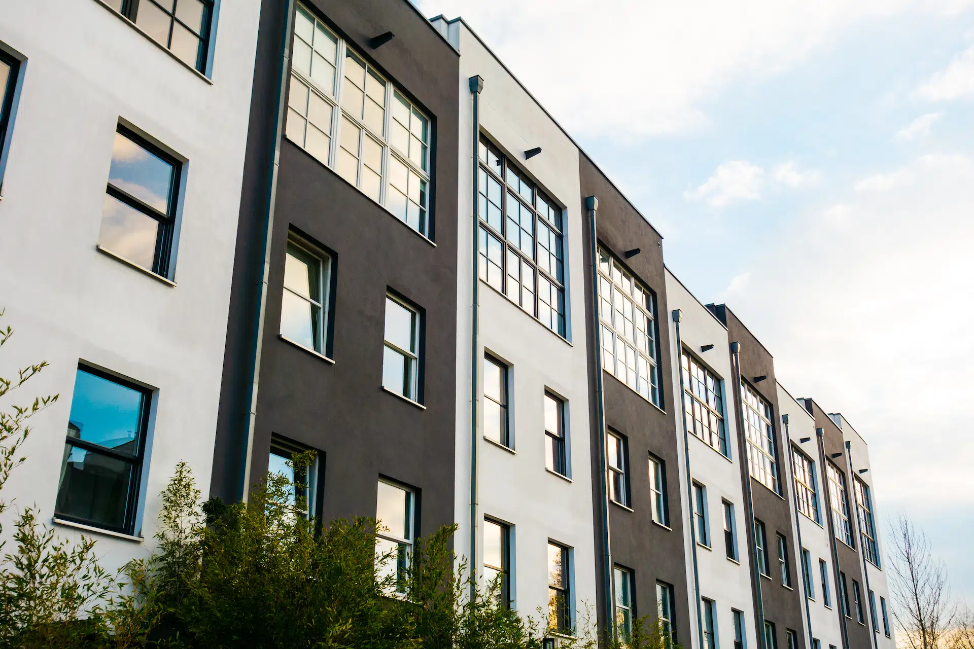 White and black townhouses with green landscaping in the Mat-Su Valley