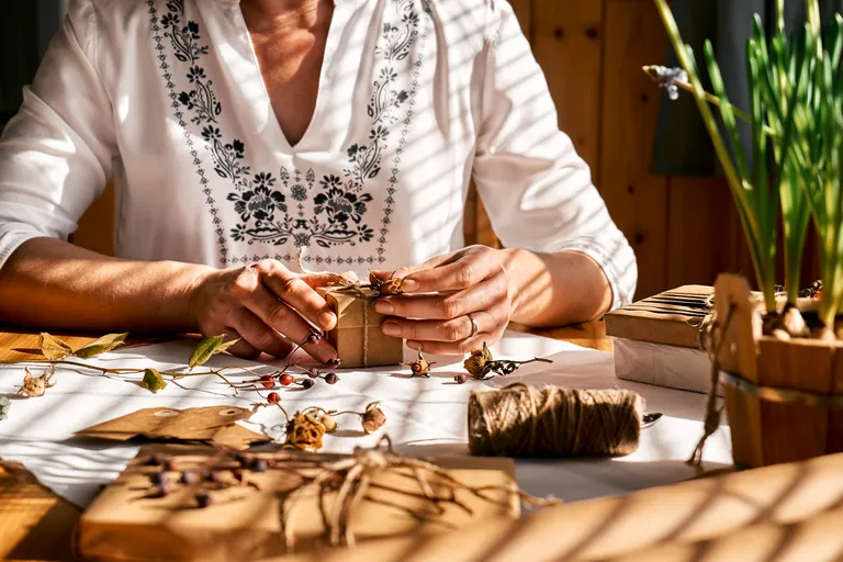 Artesana decorando regalos con materiales naturales
